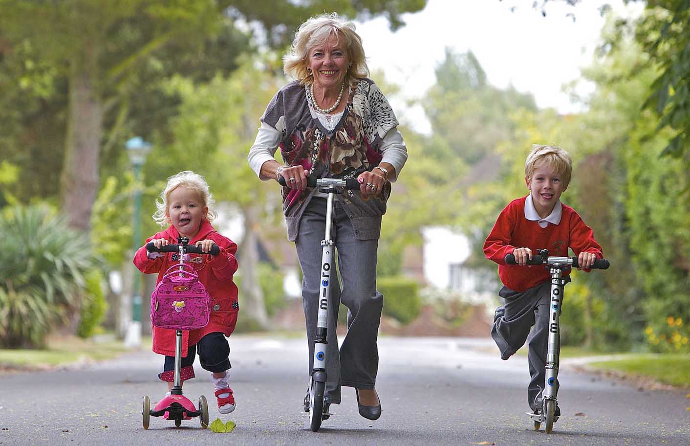 Granny takes kids to school on a scooter