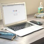 A laptop on a desk displaying the Google search page