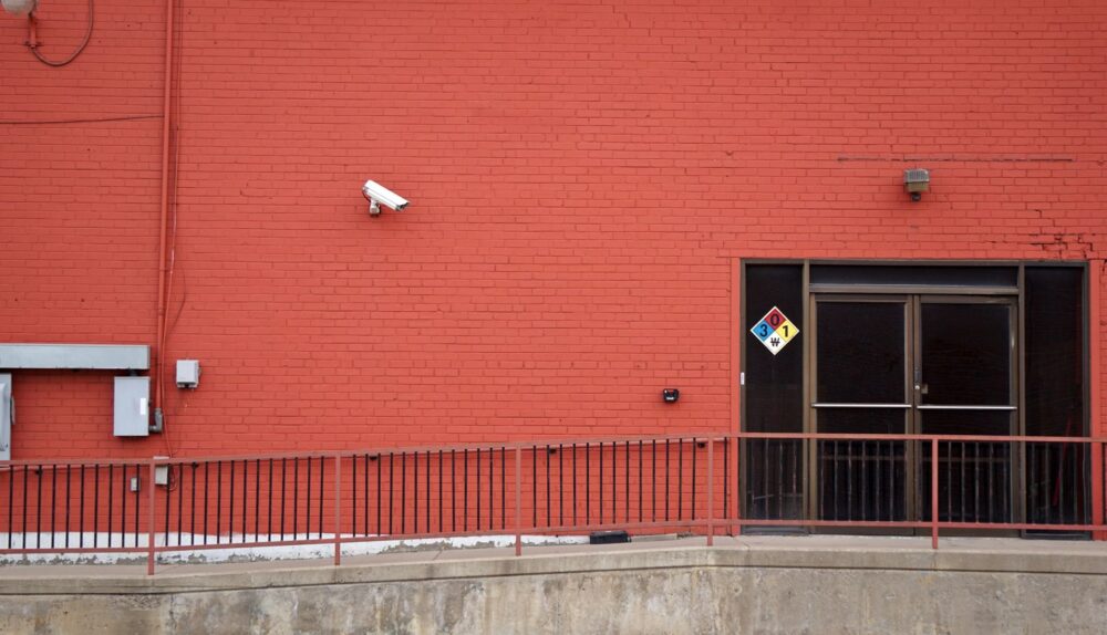Security camera and rear entrance on a commercial building: Five Warning Signs That Your Business Premises Are an Easy Target