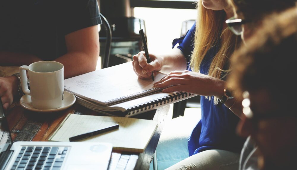 Employees discussing work around a laptop