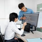 Engineers reviewing code on a monitor: So You Want to Plug In a Public-Record API? Check These Things First