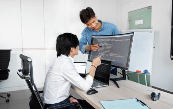 Engineers reviewing code on a monitor: So You Want to Plug In a Public-Record API? Check These Things First