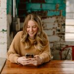 Borrower checking a loan account on a smartphone: Why Lender Support Should Not End When the Money Arrives