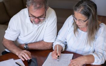 Early pension withdrawals made in haste often cause problems down the line: an older couple going through pension and retirement paperwork together at home