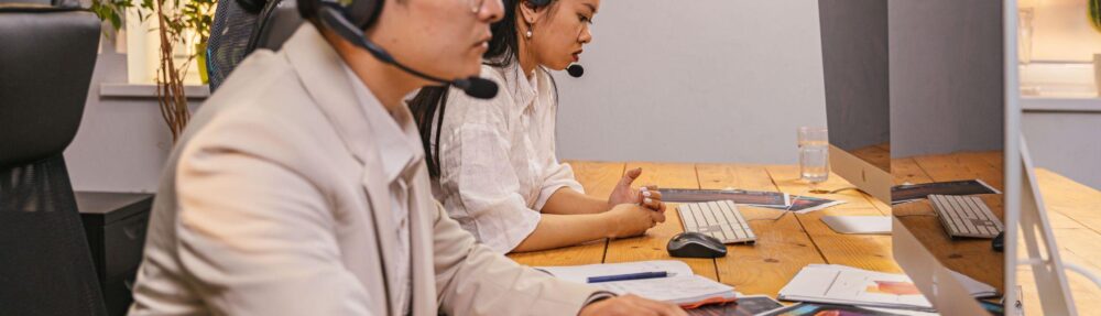 Offshore team members working at computers with headsets