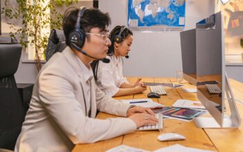 Offshore team members working at computers with headsets