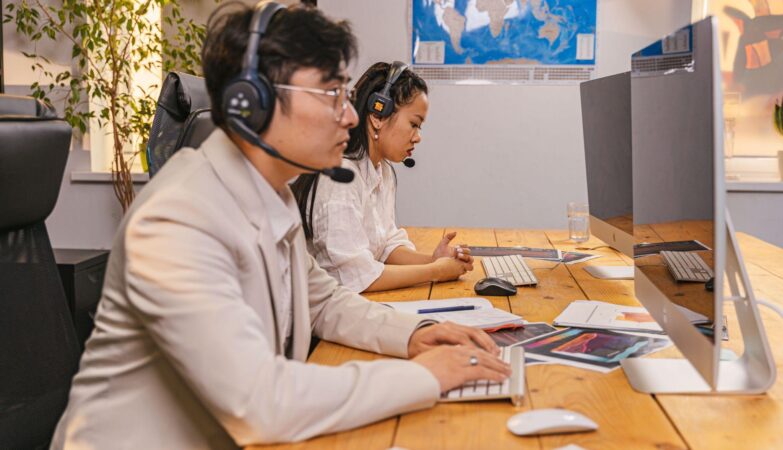 Offshore team members working at computers with headsets