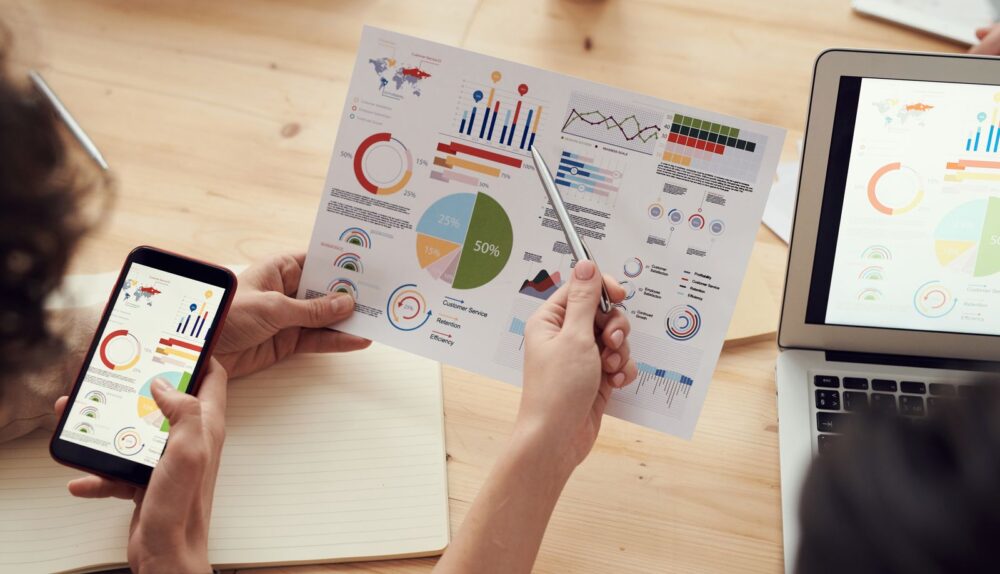 Generalist Agencies Rarely Match the Speed of Industry-Seasoned SEO Teams: marketing specialists reviewing SEO and campaign analytics charts at a desk